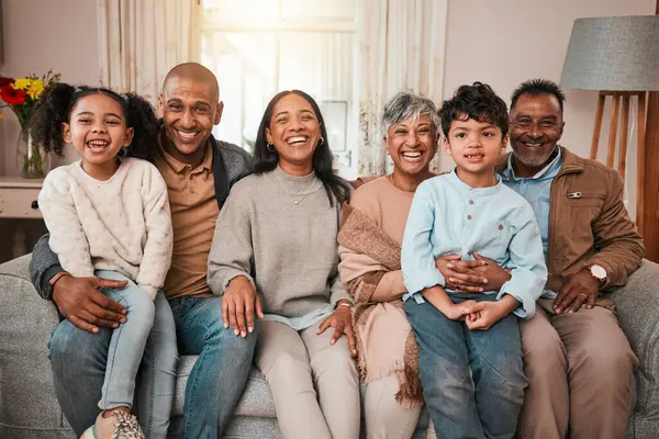 Family, generations and smile in portrait on couch, bonding with love and care at home. Happy people in living room, grandparents and parents with children relax on sofa with laughter together.