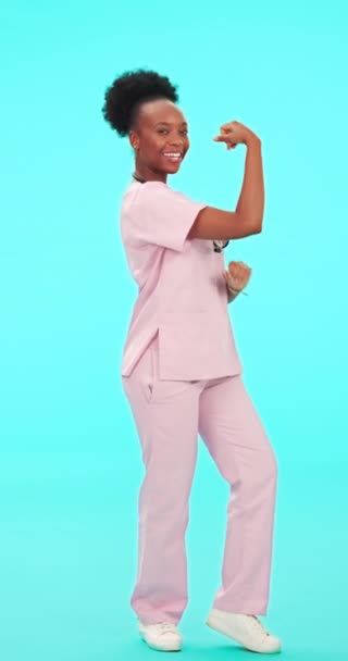 フレックス 黒い医師 女性は 青い背景に強いまたは動機のためにスタジオで交差した腕で顔を合わせます アフリカの女性保健専門家の拳 — ストック動画