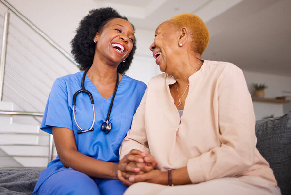 Black people, nurse and patient laughing in elderly care for funny joke, comedy or humor together on sofa at home. Happy African medical professional enjoying time with senior female person in house.