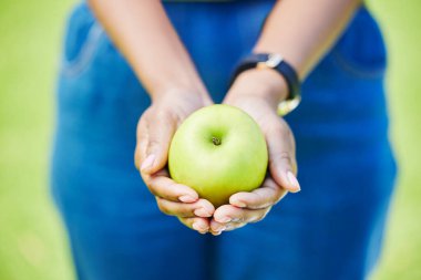 Kadın, el ve elma doğal beslenme, beslenme ya da beslenme için dışarıda sağlık ve sağlık için. Sürdürülebilirlik, vitamin veya lifli yemek için avuç içinde yeşil organik meyve bulunduran kişiye yakın çekim.