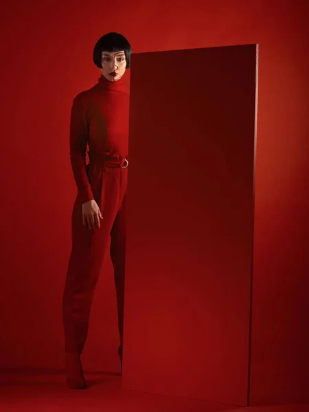 Fashion, art and portrait of woman with red board, futuristic makeup and unique studio background. Future aesthetic, cyberpunk and creative beauty, body of model in dark luxury designer brand mockup