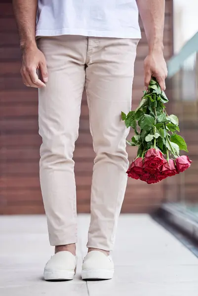 Hands, legs and man with bouquet of roses for date, romance and hope for valentines day. Love confession, romantic floral gift and person holding flowers, standing outside for proposal or engagement.