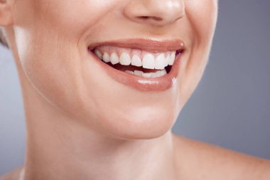 Gülümse, ağız ve diş beyazlatma stüdyoda, arka planda ve sağlıkta. Yakın plan kadın modeli, temiz diş ve taze nefesin yüzü, mutlu diş implantı ve kozmetik sonuçların estetik güzelliği..
