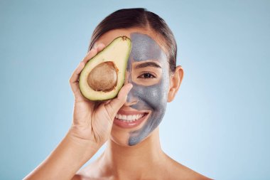 Avokado, yüz maskesi ve doğal cilt bakımı için kadın portresi, stüdyo mavi arka planda güzellik ve spa. Dermatolojide kömür maskesi, yeşil meyve ve D vitamini olan mutlu insan ya da model.