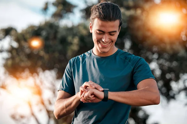 Smart watch, man and fitness at park for exercise workout, training and happy goals. Stopwatch, sports person and runner check time, heart rate or monitor healthy body progress, data app and wellness.