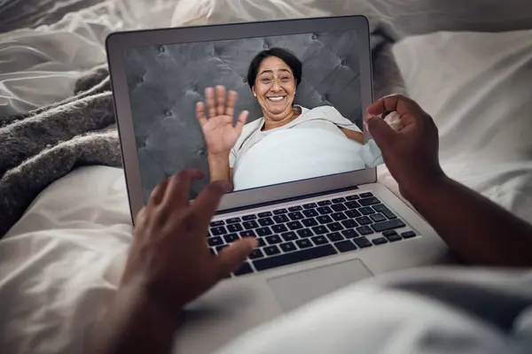 Video call, laptop screen and wave with old woman in bed for communication, social media or relax. Contact, virtual and chat with senior person in bedroom at home for morning, technology and internet.