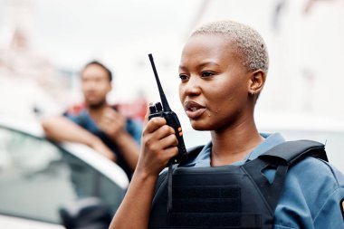 Siyahi kadın, polis ve telsiz telsizi şehir iletişimi, takviye veya acil durum için. Afrikalı kadın, güvenlik görevlisi ya da polis şehir sokaklarında devriye gezen suç için destek istiyor..