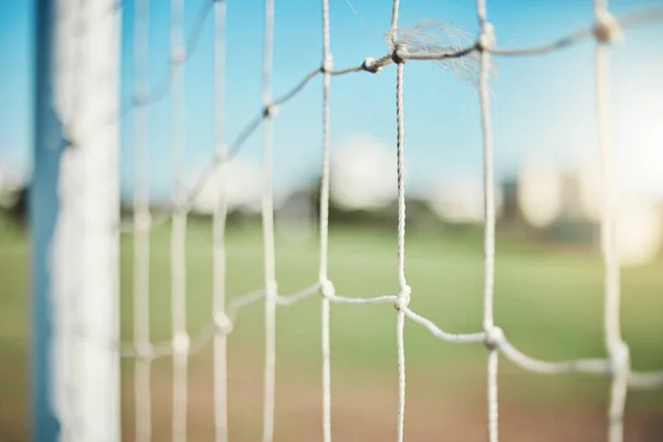 Empty, sports and goal post on soccer field for fitness training, exercise or workout outdoors. Football club, grass pitch background or closeup of blur net of game in competition or match contest.