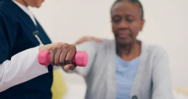Caregiver, elderly woman or dumbbell on bed to help, exercise or wellness in physiotherapy. Nurse, black person or fitness in bedroom in physical therapy, senior patient or healthcare in retirement.
