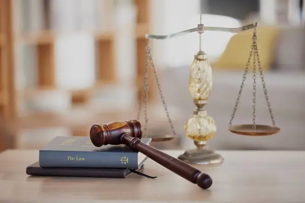 Background, gavel and law books with scales on table of judge, attorney and court trial. Closeup of legal hammer, notebook or desk of lawyer in constitution, equality and human rights of fair justice.