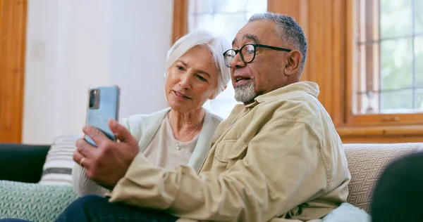 Senior couple, cellphone and communication in home for call connection, online chat or social media. Man, woman and happy partnership on mobile for internet network or speaking web, talking on couch.