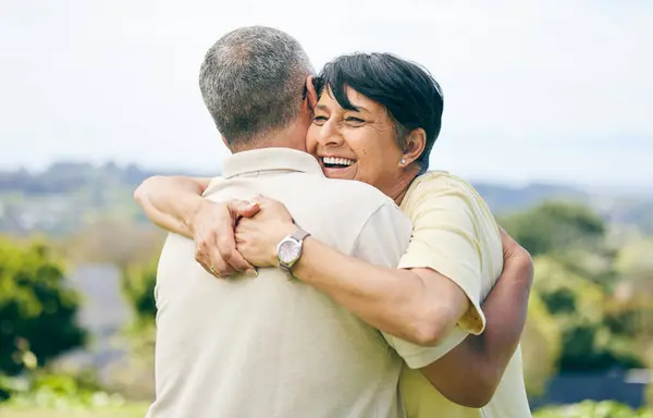 Senior woman, hug and couple together in nature with happiness, love and care for husband or partner in garden. Happy, smile on face and people in retirement park, marriage and support in embrace.