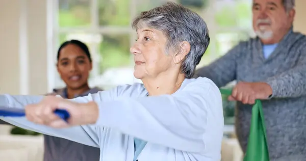 Rehabilitation, recovery or resistance band and a senior people in their home with a personal trainer. Fitness, physiotherapy or health with an elderly man and woman in their apartment for a workout.