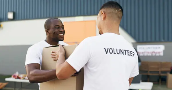 Volunteer men, helping and boxes for charity, food and clothes drive with community service for kindness. Teamwork, support and social responsibility for donation package, smile and care in workshop.