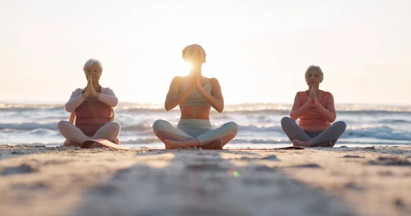 Beach yoga class, sunset and meditation instructor coaching zen mindset, spiritual chakra healing or breathing exercise. Freedom, calm and people learning pilates, training and coach teaching group.