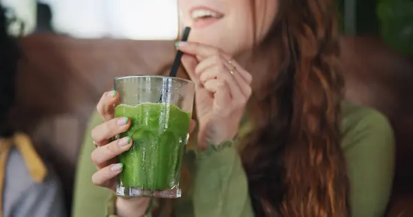 Smoothie, drink and hands of woman in restaurant with healthy, green tea or cocktail of juice with fruits and vegetables. Drinking, matcha or girl in vegan coffee shop with liquid fruit or nutrition.