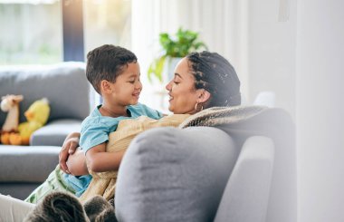 Aile, sarıl ve çocuklu bir anne ile kanepe mutlu, bağ kurun ve evlerinde birlikte rahatlayın. Aşk, gülümseme ve çocuklu anne oturma odasında kucaklaşma, rahatlama ve keyif alma ve ilişki ya da hafta sonu.