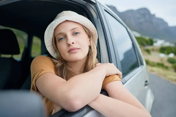 Fashion, beauty and road trip with a woman in a car for travel, vacation or holiday during summer. Face, transport and trip with an attractive young female sitting in a vehicle on a drive for freedom.