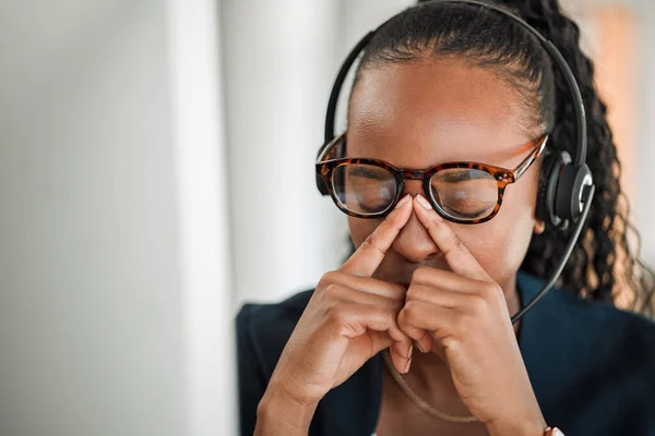 Call center stress, eye strain or black woman with headache pain due to burnout fatigue in a telecom office. Anxiety, glasses or tired consultant depressed or frustrated by long hours or migraine.