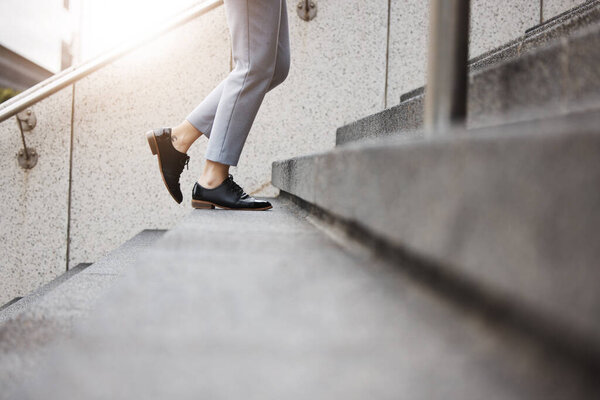 Stairs, morning person and legs walk, travel or on urban journey, outdoor commute or trip to work, destination or job. Town steps, arrival and closeup shoes, feet or agent climbing building staircase.