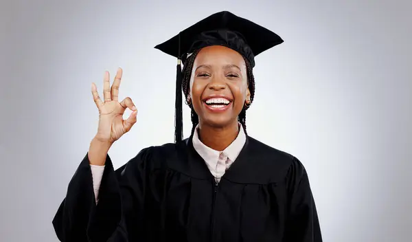 Graduation, okay hands and woman or student success in education, learning or college achievement in studio. Portrait of happy african graduate with yes or excellence emoji on a white background.