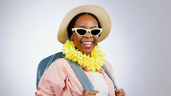 Portrait, glasses and black woman with vacation, travel and happiness on a white studio background. Face, African person and model with eyewear, hat and backpack with holiday, weekend trip or getaway.