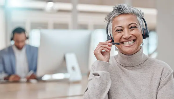 Call center, mature and face of woman with microphone in office for telemarketing, support or contact. Smile, portrait and customer service professional, sales manager or happy consultant listening.