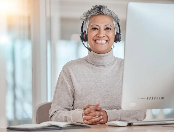 Portrait, computer and happy with a senior woman in a call center for customer service, support or assistance online. Contact, smile and an elderly consultant working at a desk in her crm office.