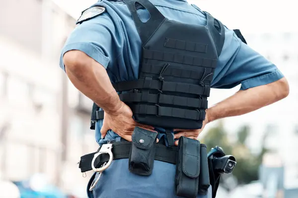Back pain, man or police officer with injury in city from accident crime, crisis danger or gunshot emergency. Law closeup, injured or security guard with painful joint, inflammation or wound in town.