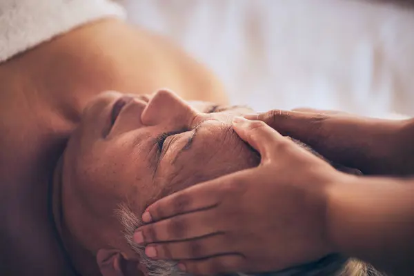 Senior woman, hands and face massage in relax for spa treatment, stress relief or body care at resort. Closeup of masseuse giving elderly female person a facial for relaxing, health and wellness.
