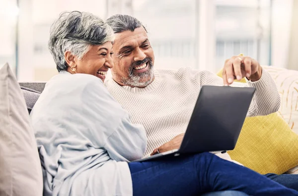 Senior, laptop or happy couple streaming comedy videos on tablet in retirement at home together. Love, old woman or elderly man bonding, watching or laughing at a funny movie or film in living room.