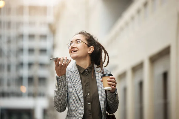 stock image Speaker phone call, outdoor and professional woman walking, planning and talk with business contact. Voice note, coffee break and female consultant on morning consultation, work trip or city commute.