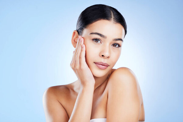Portrait, face and aesthetic with a model black woman in studio on a blue background for skincare. Relax, beauty and spa with an attractive young female posing to promote natural skin treatment.