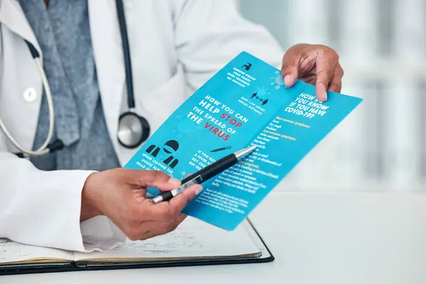 Doctor, hands and covid documents for healthcare, safety or information for advice or consultation at hospital. Person or medical professional show pamphlet, paper or poster for life insurance.