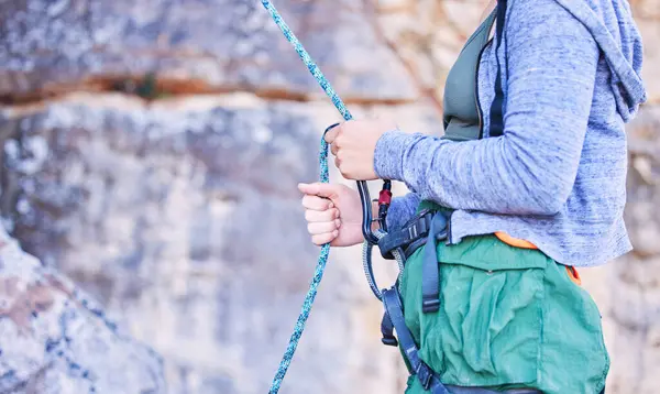 Rock climbing, mountain and hands of woman with rope for adventure, freedom and extreme sports. Fitness, outdoor and female person with safety equipment or gear closeup for training and challenge.