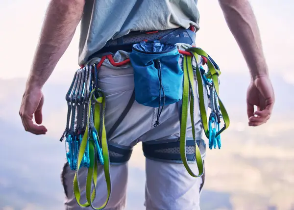 Nature, rock climbing and man with gear and harness for adventure, freedom and sports on mountain. Fitness, hiking and male person with equipment and chalk bag for training, activity and challenge.