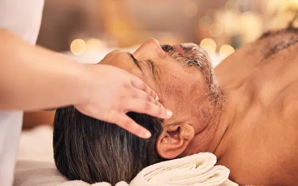 Man, facial and head massage at spa for break, skincare therapy and holistic healing at cosmetics salon. Face, peace or calm mature male client relax for zen wellness, acupressure and scalp treatment.