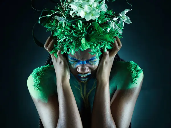 Frustrated, nature and mother earth model feeling sad from climate change in studio. Costume makeup, angry and black person with isolated and dark background upset about pollution and environment.