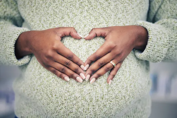 妊娠期 特写镜头和母腹上有心脏形状的妇女 以便照顾和做母亲 变焦和非洲孕妇手拉手 肚子上有爱的标志或爱抚她的孩子 — 图库照片