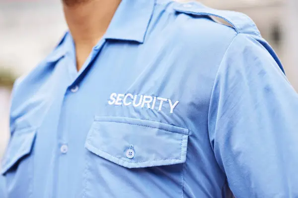 Closeup of security guard, police officer and blue shirt for crime watch, surveillance and legal safety. Person, uniform and service of cop, law enforcement worker and bodyguard on patrol for justice.