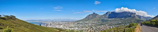 Mountain landscape and panorama view of coastal city, residential buildings or infrastructure in famous travel or tourism destination. Copy space and scenic blue sky of Table Mountain in South Africa.