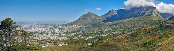 Panoramic landscape view of the majestic Table Mountain and city of Cape Town in South Africa. Beautiful scenery of a popular tourist destination and national landmark with cloudy blue sky copy space.