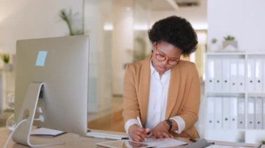 Masaüstü bilgisayarı ve tablet üzerinde çalışan genç bir bayan asistan planlarını bir takvim çizelgesine yazıp yazıyor. Modern bir ofiste çalışan Afrikalı bir Amerikalı kadın yönetici..