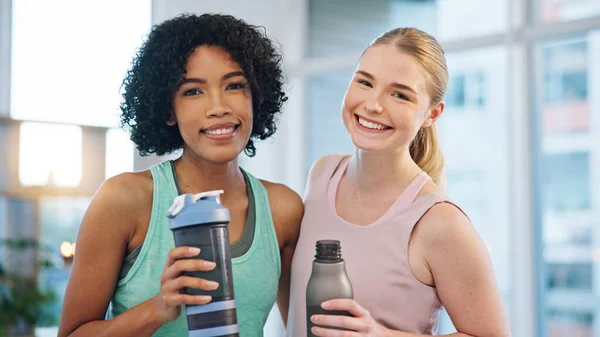 Fitness, friends and face of women hug at a sports studio after yoga, training or workout together. Exercise, portrait and happy woman embrace personal trainer at gym for pilates, wellness or health.