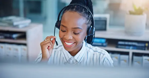 Black woman, call center and consulting on headphones in customer service, support or telemarketing at office. African female person, consultant or agent talking in online advice or help at workplace.