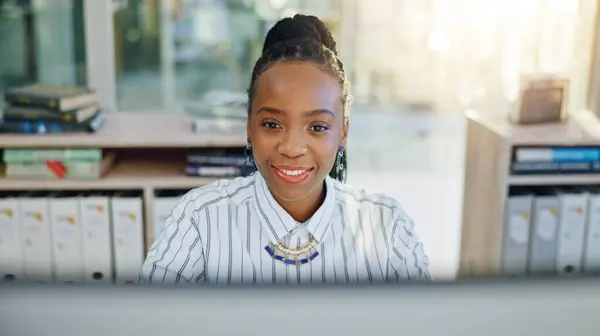 Business, black woman and smile at computer in office for planning online report, typing email and internet research. Face of worker at desktop tech for project update, administration and information.