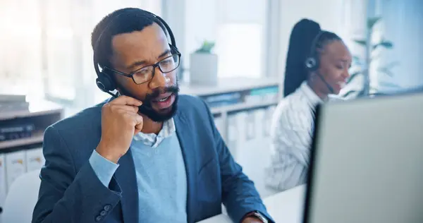 Computer, customer support and a black man consultant working in a call center for service or assistance. Contact, crm and headset communication with an employee consulting in a retail sales office.
