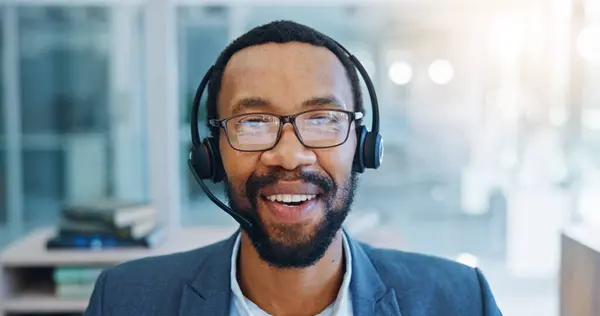 Black man, face and call center consulting with headphones in customer service or telemarketing at office. Portrait of happy African male person, consultant or agent talking in online advice or help.