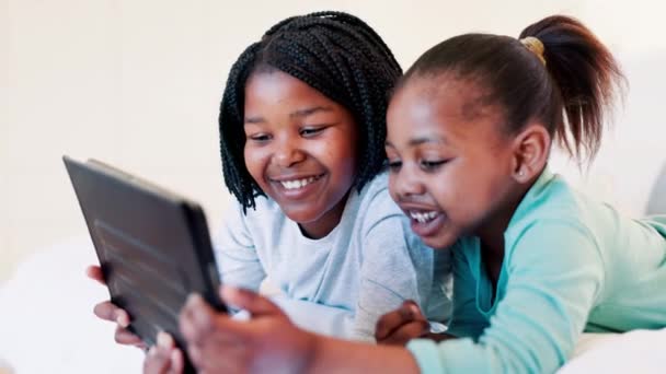 タブレット オンラインゲーム 面白いビデオ 家庭教育 または幸せな学習のためのベッドでリラックスしてください 寝室で映画やフィルムをストリーミングするためのデジタル技術に関する少女 アフリカの家族 — ストック動画