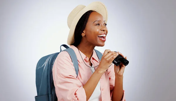 Black woman, travel and binoculars from holiday and backpack in a studio. Relax, hiking and smile with camping and excited with an African female person from Kenya with holiday and adventure freedom.